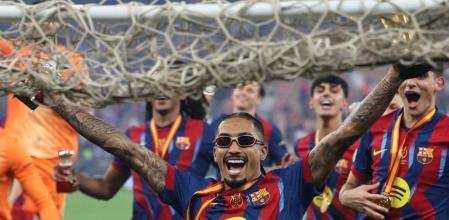 Barcelona's Brazilian forward #11 Raphinha celebrates with teammates after winning the Spanish Super Cup final football match between FC Barcelona and Real Madrid at the King Abdullah Stadiumin Jeddah on January 11, 2026. (Photo by Fadel SENNA / AFP)