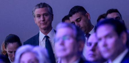 Gavin Newson parece reírse de esa primera fila de cargos de la Casa Blanca (Susie Wiles, Scott Bessent y Marco Rubio) durante la intervención de Trump en Davos este miércoles 