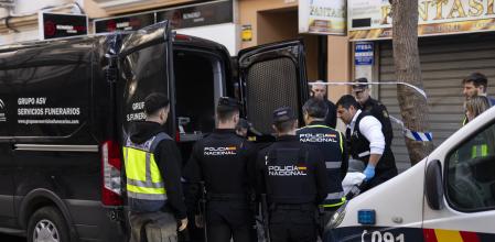 La Policía Nacional y trabajadores de los servicios funerarios trasladan el cuerpo de uno de los fallecidos en Fuengirola (Málaga)