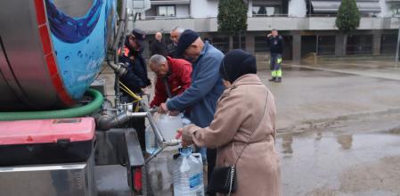 Vecinos de Sils llenan sus garrafas en un camión cisterna que repartirá agua a diario hasta que la situación se normalice.