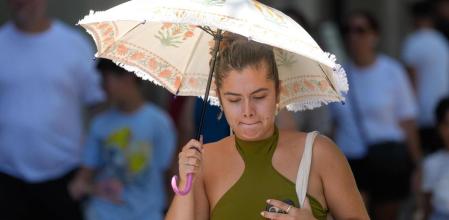 Una mujer se protege del sol en el centro de Barcelona