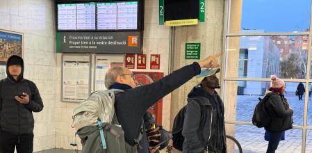 Un pasajero mira una pantalla con la informadora en la estación de Girona&nbsp;