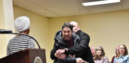 Moment en què l’agressor és detingut després d’haver llançat el líquid a la congressista (d’esquena) amb una xeringa