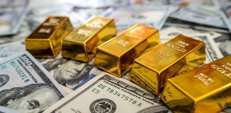 Gold bullions on hundred dollars banknotes and chart background