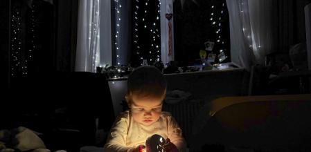 Una nena de deu mesos s’escalfa amb un llum de gas a Lviv