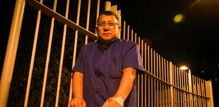 El conserje Rubén Bravo, subido en su escalera frente a las verjas del Turó Park