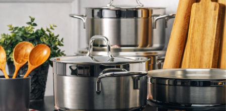 Batería de cocina Zwilling de acero inoxidable colocada sobre fogones, con ollas y cacerolas en un entorno de cocina doméstica