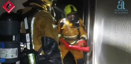 Bomberos del Consorcio Provincial de Alicante derriban la puerta de una de las habitaciones del hostal El Altet