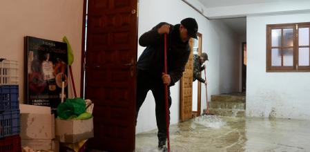 Vecinos de Grazalema intentan achicar agua de sus casa y locales debido a las intensas lluvias que se registran este miércoles&nbsp;