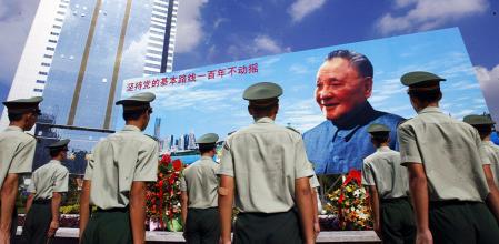 Un grupo de soldados ante un cartel en homenaje a Deng Xiaoping /&nbsp;