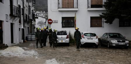 Un grupo de bomberos este jueves en Grazalema, con las calles inundadas ante las intensas lluvias