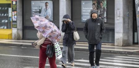 Imagen de recurso de una mujer protegiéndose de la lluvia durante el enjambre de borrascas que ha atravesado Andalucía las últimas semanas. 