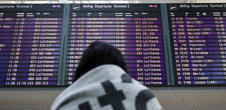 Una pasajera mira el tablero de vuelos en un aeropuerto alemán.
