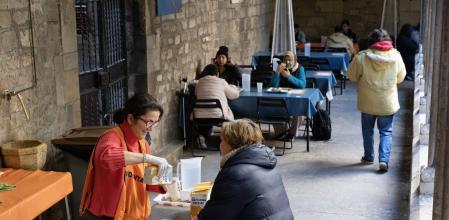Una voluntaria de Santa Anna sirviendo hoy el almuerzo a una usuaria&nbsp;