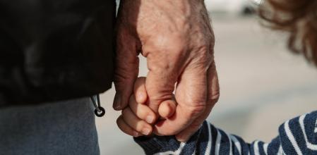 Abuelo sosteniendo la mano de su nieto 