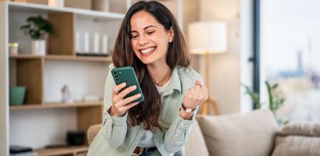 Una chica, contenta por haber comprado uno de sus artículos favoritos por menos dinero en Amazon