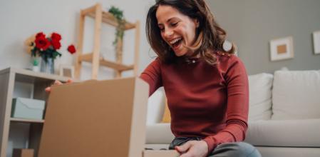 Una mujer reacciona con una sonrisa tras recibir un paquete de AliExpress