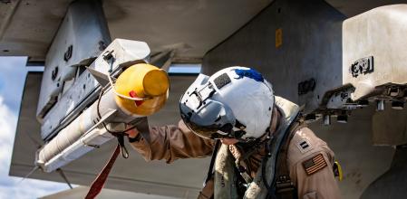 Un tripulante del YSS Ford revisa un F/A-18E Super Hornet.