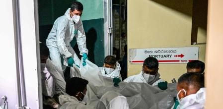 Enfermeros de Sri Lanka trasladan bolsas con cadáveres rescatados del mar tras el hundimiento de la fragata iraní.