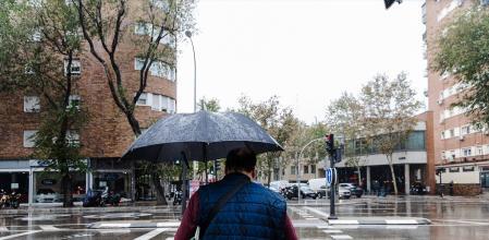 Un hombre se protege de la lluvia con un paraguas