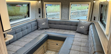 Una furgoneta cámper funcional con un gran salón convertible en dormitorio y vistas a tres vientos