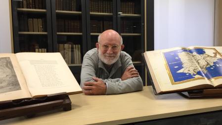 Manuel Desantes, entre dos ejemplares de la valiosa biblioteca de libros antiguos que ha cedido y expone en el Colegio de Notarios de Alicante