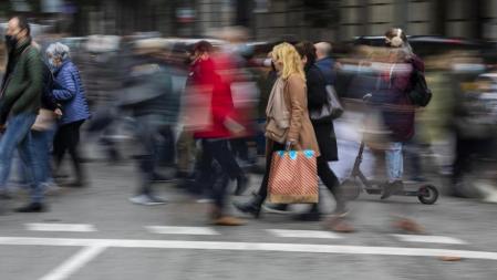 FOTO: MANÉ ESPINOSA. AMBIENTE DE COMPRAS DE NAVIDAD EN PORTAL DE L’ ANGEL EL VIERNES DEL BLAKE FRIDAY. UNA MUJER CRUZA EL PASO DE PEATONES CON UNA BOLSA DE PRIMARK
