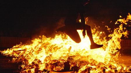 Una mujer saltando una hoguera de San Juan