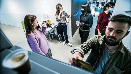foto XAVIER CERVERA 12/04/2021 tras muchos meses d pandemia por coronavirus el reencuentro -tras el teletrabajo- en la oficina sera mas presente, como por ejemplo, frente a la maquina de cafe del espacio comun d comida bebida, con y sin mascarilla, si se consume o se charla o...