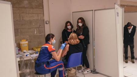 A woman receives a Pfizer COVID-19 vaccine by a member of the Civil Protection service, while her daughters waiting for their turn at a shopping mall in Paris, Tuesday, July 13, 2021. More than 1 million people in France made vaccine appointments in less than a day after the president cranked up pressure on everyone to get vaccinated to save summer vacation and the French economy. (AP Photo/Michel Euler)