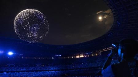 Tokyo (Switzerland), 23/07/2021.- A photographer takes pictures of drones forming a globe in the sky over the stadium during the opening ceremony of the 2020 Tokyo Summer Olympics at the National Stadium in Tokyo, Japan, 23 July 2021. (Japón, Tokio) EFE/EPA/PETER KLAUNZER