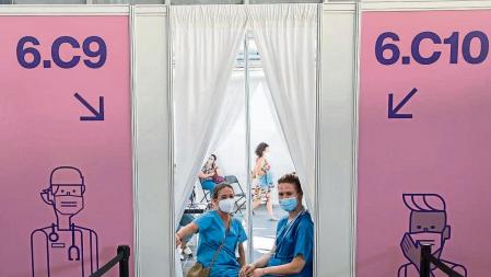 CENTRO DE VACUNACION MASIVA DE LA FIRA DE BARCELONA, CON LA INCORPORACIÓN DE JOVENES PARA VACUNARSE. DOS ENFERMERAS ESPERAN PACIENTES PARA VACUNARSE CON ASTRAZENECA