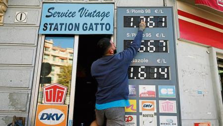 FILE PHOTO: An employee updates fuel price signs at a petrol station in Nice, France, October 13, 2021. REUTERS/Eric Gaillard/File Photo