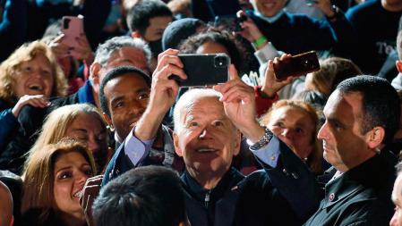 TOPSHOT - US President Joe Biden takes selfies with the crowd after a campaign event for Virginia Democratic gubernatorial candidate Terry McAuliffe at Virginia Highlands Park in Arlington, Virginia on October 26, 2021. (Photo by Nicholas Kamm / AFP)