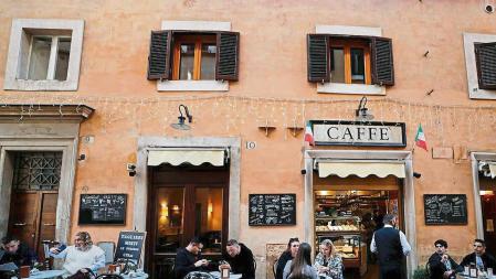People sit at a bar, as the government discusses more stringent rules for the coronavirus disease (COVID-19) health pass known as a Green Pass, in Rome, Italy November 24, 2021. REUTERS/Yara Nardi