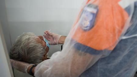 A member of the civil protection ambulance service administers a swab test during Covid-19 testing for unvaccinated passengers or those arriving from a designated 'Red Zone' country, at Paris-Charles de Gaulle airport in Paris, France, on Tuesday, Dec. 14, 2021. France is considering tightening Covid testing rules for travelers coming into the country from the U.K., French government spokesman Gabriel Attal said on France Info radio. Photographer: Nathan Laine/Bloomberg