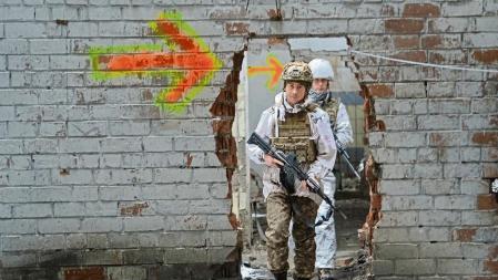 Ukrainian service members walk on the front line at the industrial zone of government-held town of Avdiyivka in Donetsk region, Ukraine December 17, 2021. REUTERS/Oleksandr Klymenko