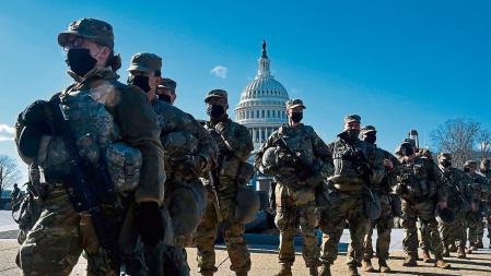 (FILES) In this file photo taken on January 19, 2021, members of the National Guard gather at a security checkpoint near the US Capitol, ahead of the 59th inaugural ceremony for President-elect Joe Biden and Vice President-elect Kamala Harris in Washington, DC. - On January 6, 2021 they descended upon Washington, DC in the thousands, gathering to protest the result of a presidential election they still claim was 