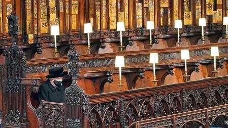 FILE - Britain's Queen Elizabeth II sits alone in St. George's Chapel during the funeral of Prince Philip, the man who had been by her side for 73 years, at Windsor Castle, Windsor, England, Saturday April 17, 2021. Boris Johnson's former communications chief has apologized 