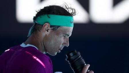 Spain's Rafael Nadal cools off with an air conditioner by the players seats during his match against Canada's Denis Shapovalov in their men's singles quarter-final match on day nine of the Australian Open tennis tournament in Melbourne on January 25, 2022. (Photo by Aaron FRANCIS / AFP) / -- IMAGE RESTRICTED TO EDITORIAL USE - STRICTLY NO COMMERCIAL USE --