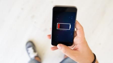 Un joven sostiene su iPhone sin batería