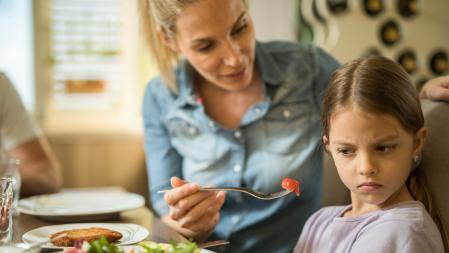 Una madre con una niña que no quiere comer