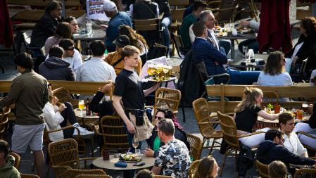This photograph taken on April 21, 2022 shows a waiter working on a terrasse in the center of Utrecht. - After months of restrictive measures due to the Covid-19 coronavirus, many restaurant businesses are unable to fully open because of staffing shortages. (Photo by Ramon van Flymen / ANP / AFP) / Netherlands OUT