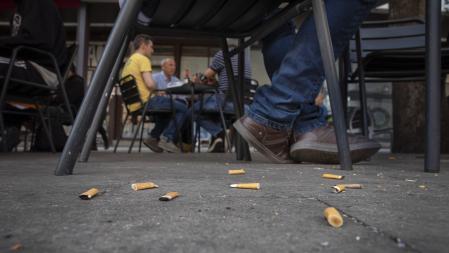 Colillas en el suelo en la terraza de un bar