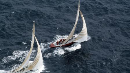 The American yacht, Liberty (right) leading Australia II during the first race of the America's Cup series in Newport, Rhode Island, 14th September 1983. In September 1983, the 12 metre yacht Australia II made history when the oldest sporting trophy in the World, the America's Cup, was wrested from the Americans after 132 years. The Australia II was owned and built by a syndicate of Western Australians headed by Alan Bond. The syndicate had unsuccessfully challenged for the Cup three times. America's Cup veteran Dennis Conner, was charged with defending the trophy against the Australians. The designer of Australia II, Ben Lexcen, had conceived a winged keel that under secret testing in the Netherlands had out-performed conventional keels. The series took place at Newport, Rhode Island and it certainly did not begin well for Australia II, with the Americans taking an early lead in the best of seven races. After four races the American boat 'Liberty' had a lead of 3-1. Against all odds, Australian skipper Jean Bertrand battled back, eventually bringing the score level at 3-3. The seventh and final race was symbollic of the entire series, with Conner's Liberty leading for most of the course in a light and shifty breeze. It was not until the final spinnaker run that Australia II was able to jump into the lead. For the first time since 1851 the America's Cup would be leaving the New York Yacht Club. (Photo by Leo Mason/Popperfoto via Getty Images)