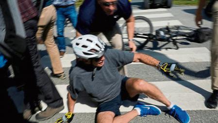 U.S. President Joe Biden falls to the ground after riding up to members of the public during a bike ride in Rehoboth Beach, Delaware, U.S., June 18, 2022. REUTERS/Elizabeth Frantz TPX IMAGES OF THE DAY