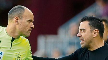 BARCELONA, 31/12/2022.- El entrenador del FC Barcelona, Xavi Hernández, conversa con el árbitro Antonio Mateu Lahoz durante el partido de LaLiga Santander disputado contra el RCD Espanyol ste sábado en el estadio Spotify Camp Nou de Barcelona. EFE/Andreu Dalmau
