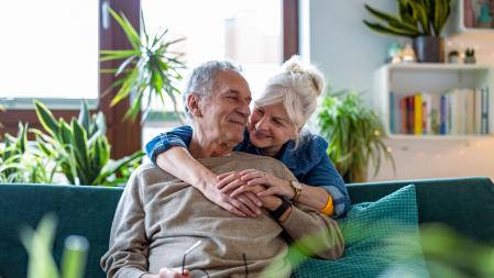 Portrait of a happy senior couple sitting on sofa at home
