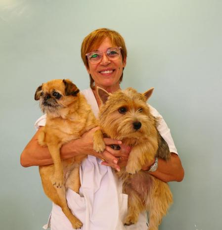 Merche Muñoz sujetando a dos clientes perrunos