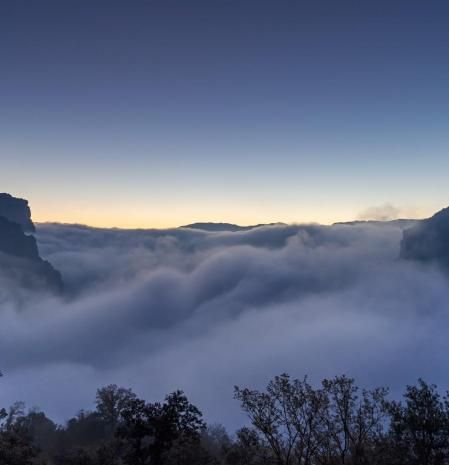 Mar de niebla sobre el embalse de Sau, con la luna menguante, al salir el sol y con el cielo azul.